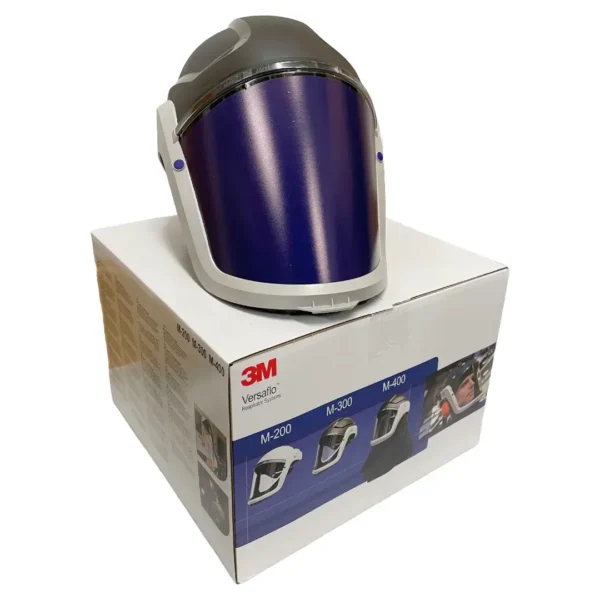 3M Versaflo M-306 Helmet – Industrial-grade respiratory and eye protection helmet with a dark visor and robust headgear, displayed on top of its original 3M packaging. Designed for protection in hazardous work environments, compatible with Versaflo PAPR systems.